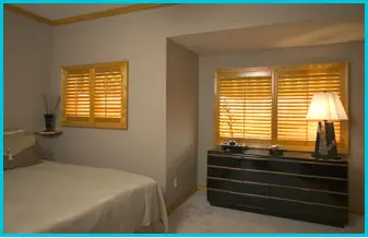 gold oak stained atlantic wood shutters in bedroom