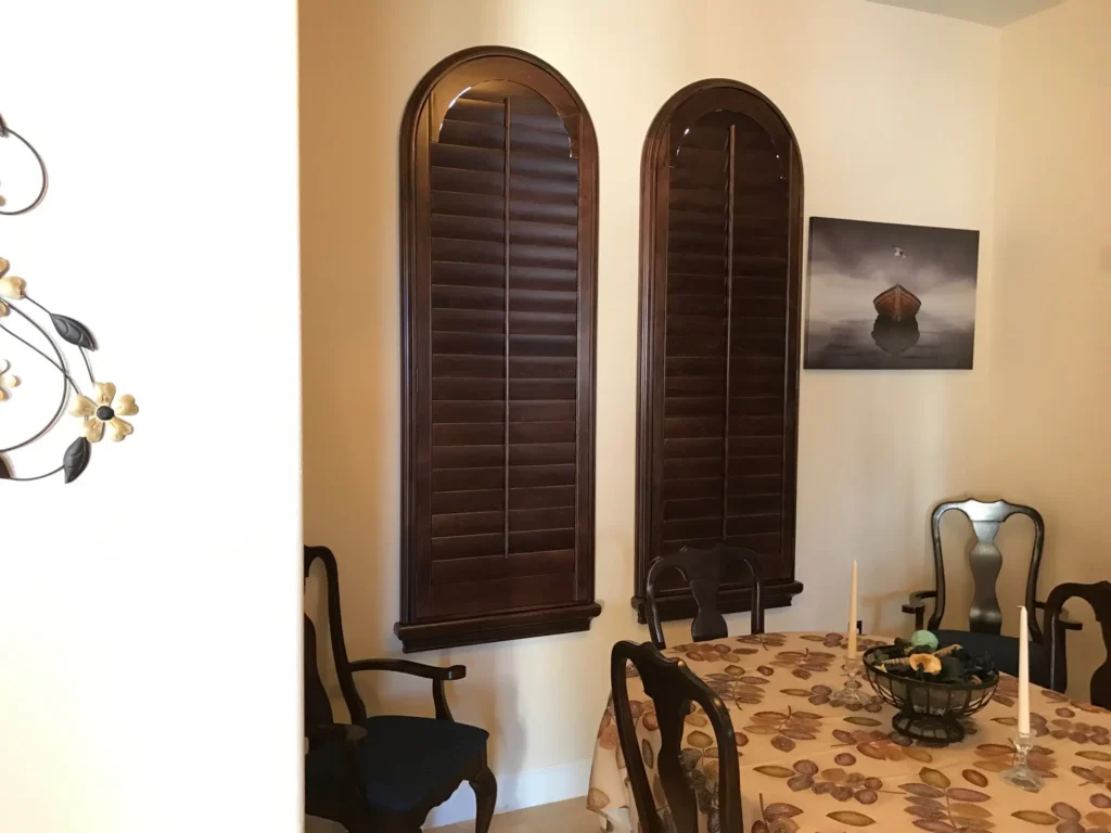 stained atlantic wood shutters in arched shape